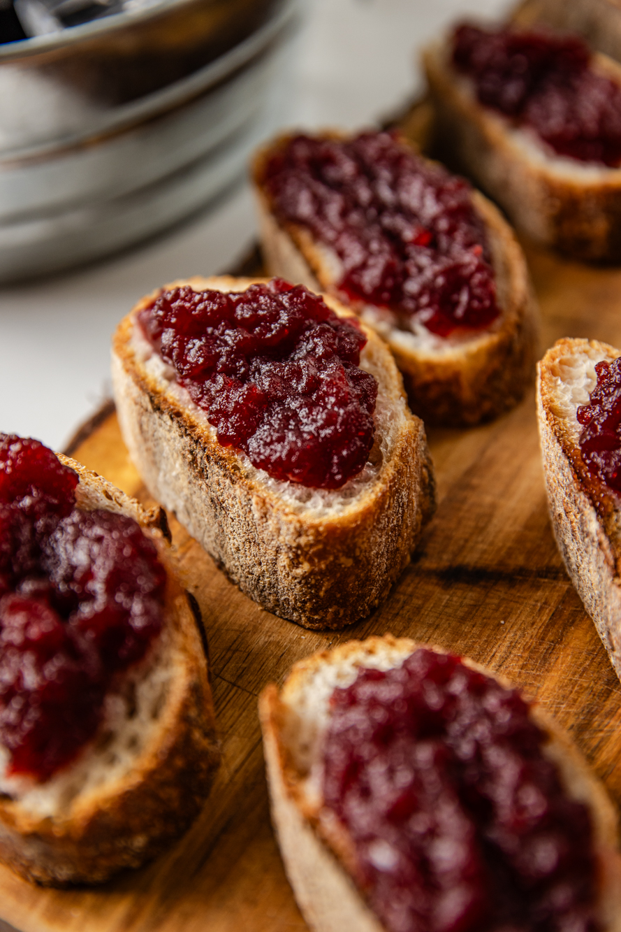 Close up shot of cranberry sauce on mini toasts