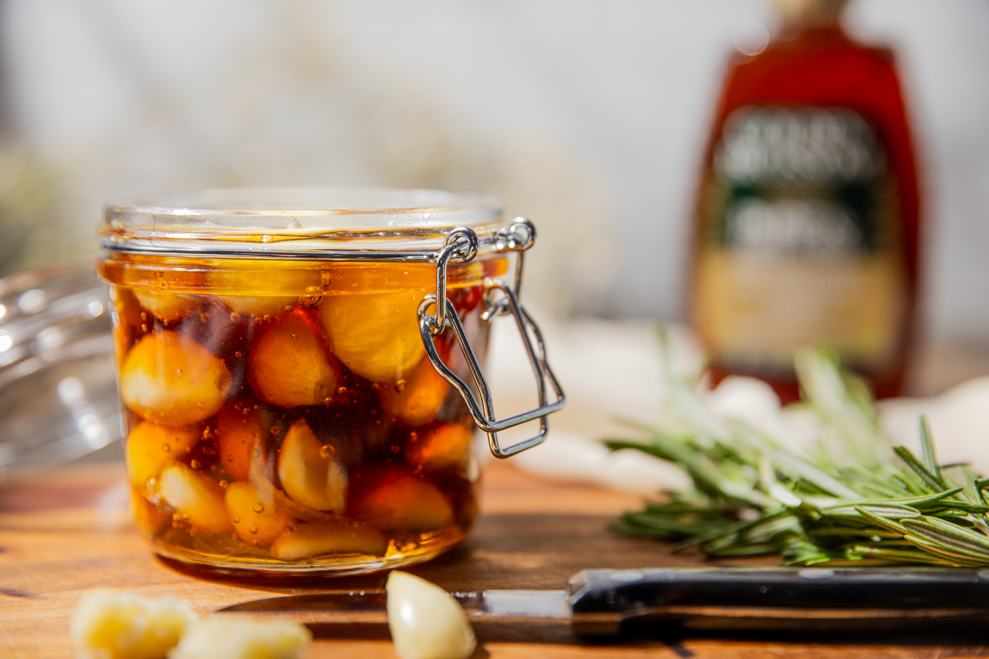 A jar filled with Garlic submerged in Honey